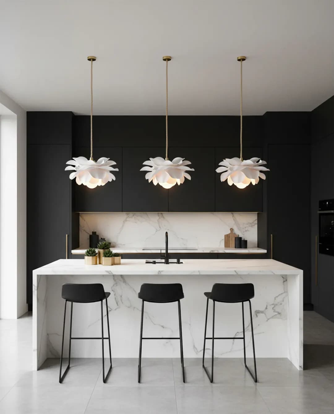 Three white flower pendant lights in a row above a marble kitchen island