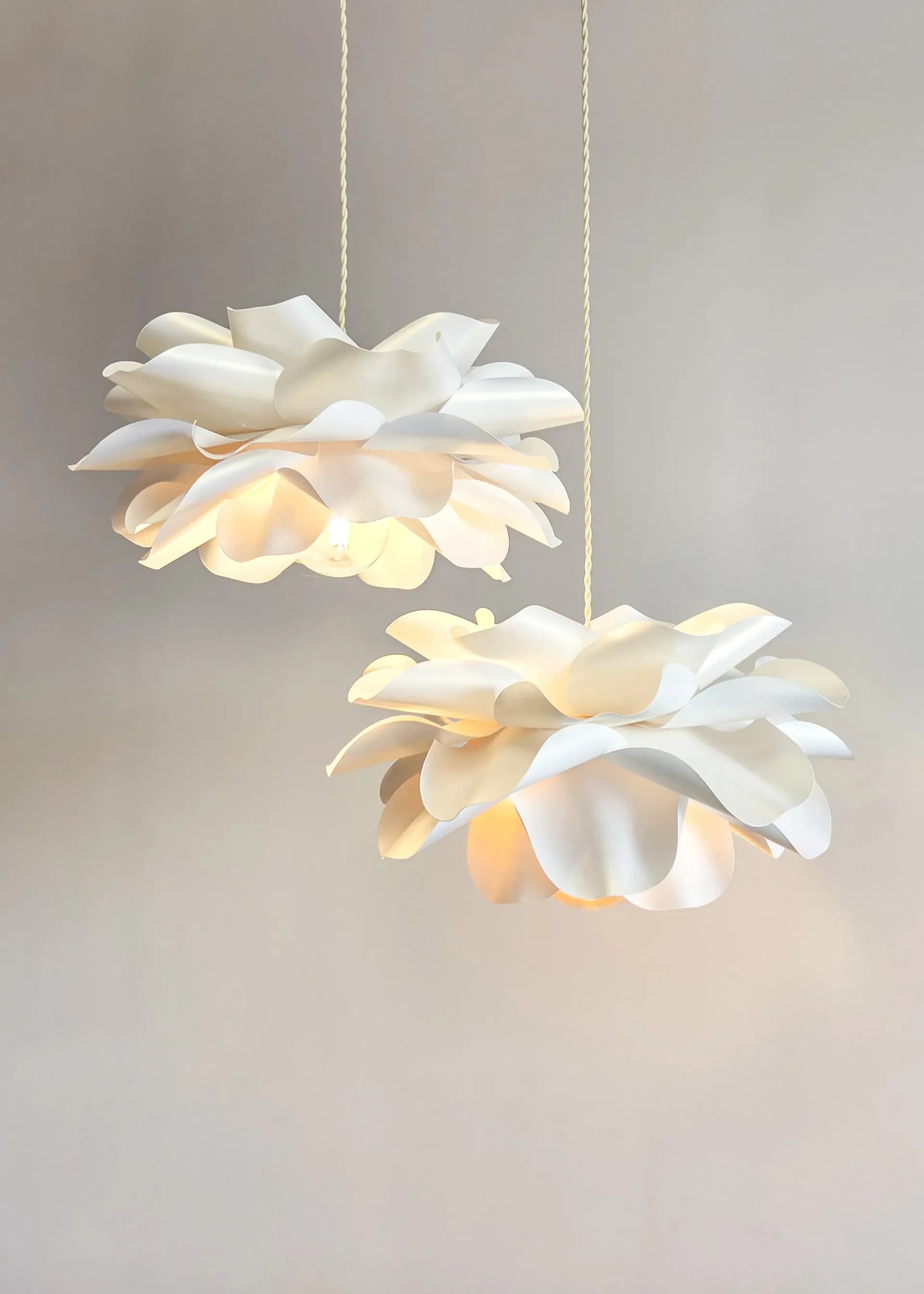 Set of two flower pendant lamps glowing at different heights